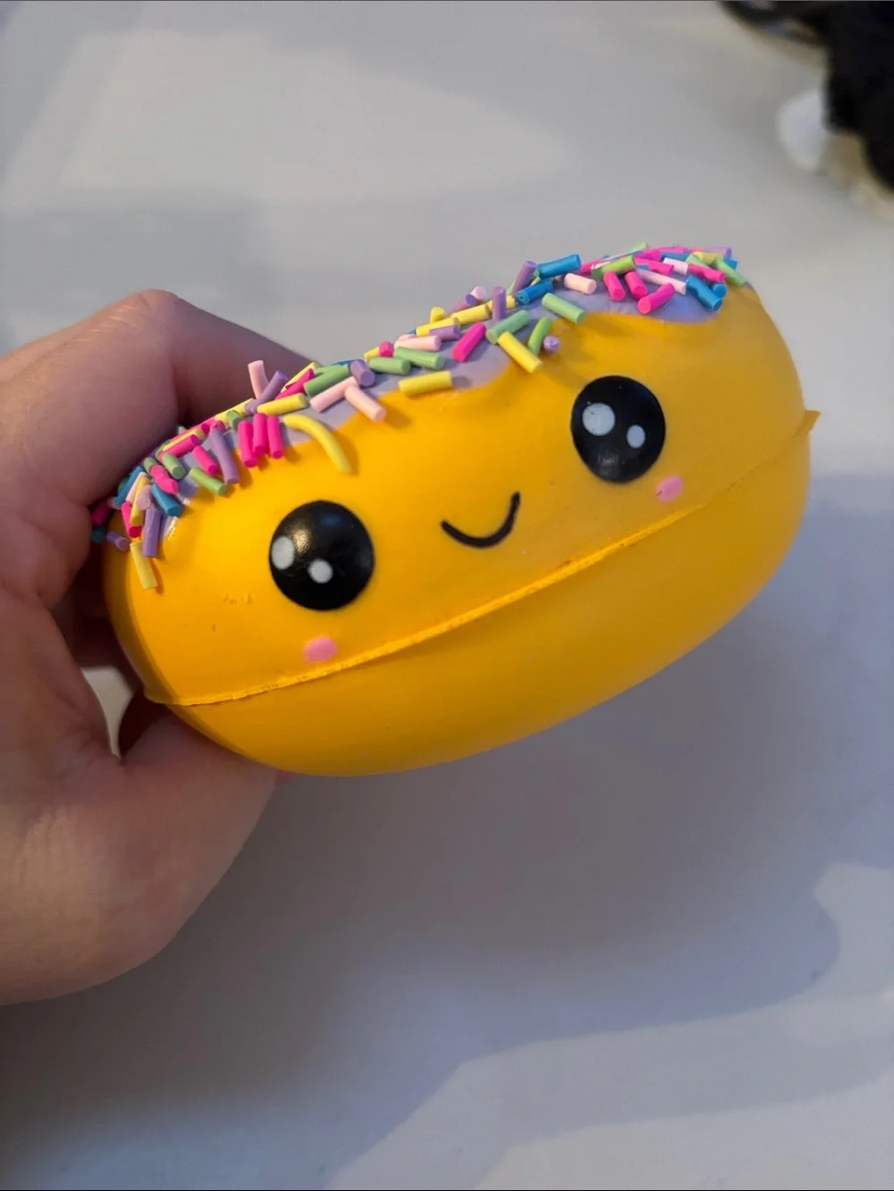 Smiling Yellow Donut Plush Toy with Purple Frosting and Rainbow Sprinkles